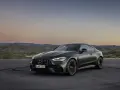 Mroczny Mercedes CLE 53 AMG na tle górskiego krajobrazu o zachodzie słońca.