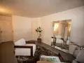 Un salotto moderno con poltrone bianche, un grande specchio e una Vespa. Perfetto per chi ama dipingere casa con stile.