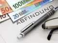 Euro-Scheine liegen neben einem Dokument mit dem Wort "Abfindung". Ein Stift und eine Brille deuten auf eine bevorstehende Entscheidung hin, vielleicht eine Abfindung nach 4 Jahren.