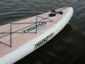 Ein aufblasbares SUP liegt im Wasser. Das Board hat eine Holzoptik und das Logo "THURSO SURF" ist gut sichtbar. Perfekt zum SUP lagern.
