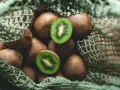 Kiwi freschi in una retina verde, pronti per essere gustati. Un'immagine che evoca il momento quando si raccolgono i kiwi.