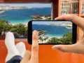 Jak podłączyć telefon do telewizora przez HDMI? Widok na plażę z palemami na ekranie telefonu i telewizora.