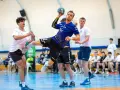 Łukasz Wolski w akcji, rzuca piłkę do bramki podczas meczu piłki ręcznej.