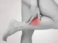 Frau tastet schmerzendes Bein ab, ein roter Fleck deutet auf einen möglichen Thrombose-Test hin.