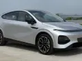 Srebrny SUV XPENG G6 z czarnymi felgami na tle krajobrazu.