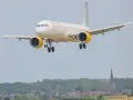 Samolot hiszpańskich linii lotniczych z żółtymi silnikami zbliża się do lądowania nad malowniczą miejscowością.