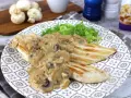 Sabroso pollo con champiñones en salsa cremosa, servido con lechuga fresca en un plato decorado.