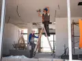 Dwóch budowlańców na drabinach montuje instalację elektryczną. Czy jest ulga na remont mieszkania?