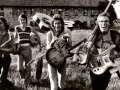 Vier Musiker mit Gitarren und Saxophon, ein Schlagzeuger. Eine Szene, die an deutsche Bands der 70er erinnert, voller Energie und Musik.