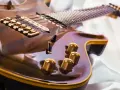 Glänzende E-Gitarre mit goldenen Details, bereit, um das Gitarre lernen zu beginnen.