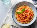 Misternie ułożone spaghetti z sosem pomidorowym i listkiem bazylii. Idealne jakie przyprawy do spaghetti? Sól, pieprz i odrobina czosnku.