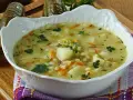 Aksamitna zupa ogórkowa na żeberkach, pełna ziemniaków, marchewki i koperku, z ogórkami w tle.