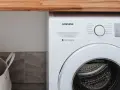 Biała pralka Samsung z technologią Digital Inverter. Obok kosz na pranie.
