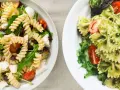 Due ciotole di pasta fredda gourmet: una con fusilli, melanzane, pomodorini e mozzarella; l'altra con farfalle al pesto e pomodorini.