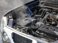 Steam rises from an overheated car radiator, indicating a potential engine problem.