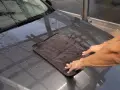 Hände trocknen mit einem Mikrofasertuch die Motorhaube nach der Autowäsche. Perfekt für das auto innenraum trocknen.