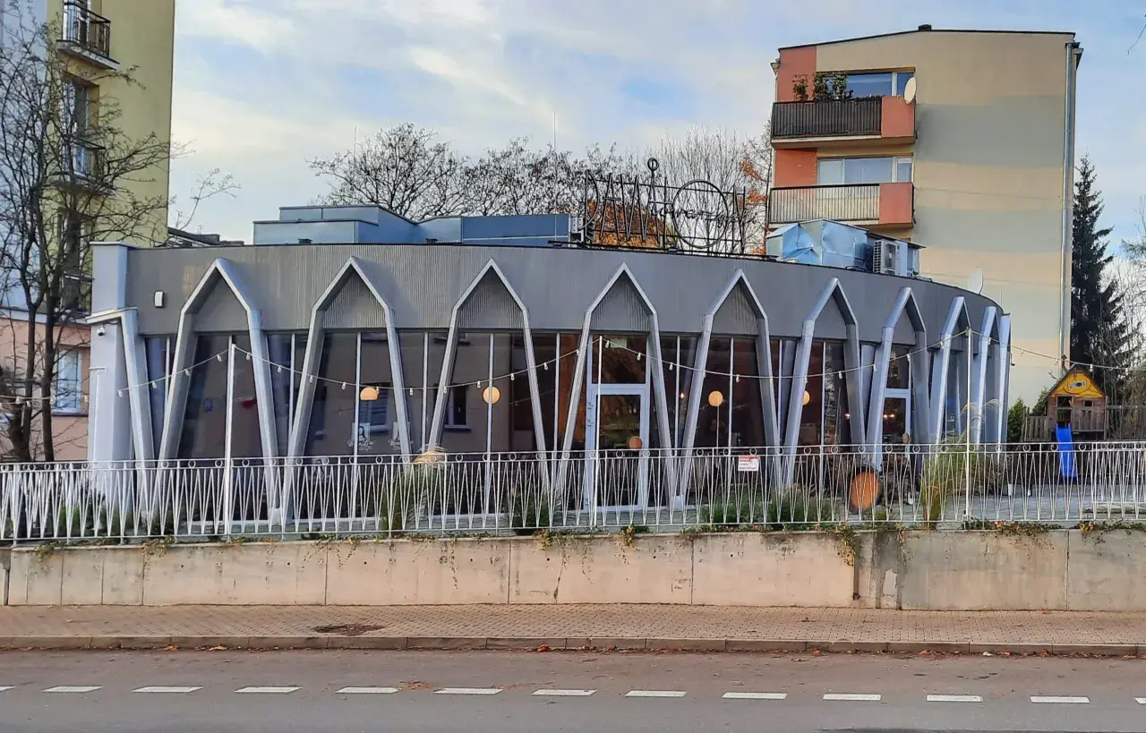 Charakterystyczna modernistyczna architektura budynku z przeszkloną fasadą i geometrycznymi elementami.