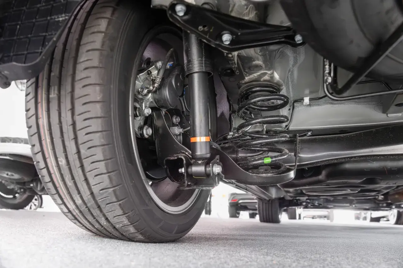 Widok od spodu samochodu z kołem, amortyzatorem i sprężyną. To auto ma rwd napęd, co zapewnia świetne wrażenia z jazdy.