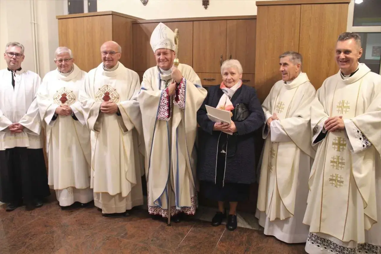 Uroczystość z udziałem biskupa i duchownych. Wśród nich stoi kobieta, która jest wdową konsekrowaną.