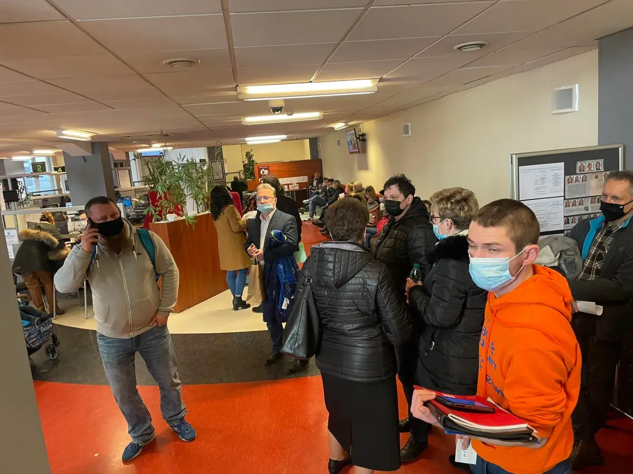 Kolejka ludzi w biurze paszportowym w Częstochowie. Niektórzy mają maseczki.