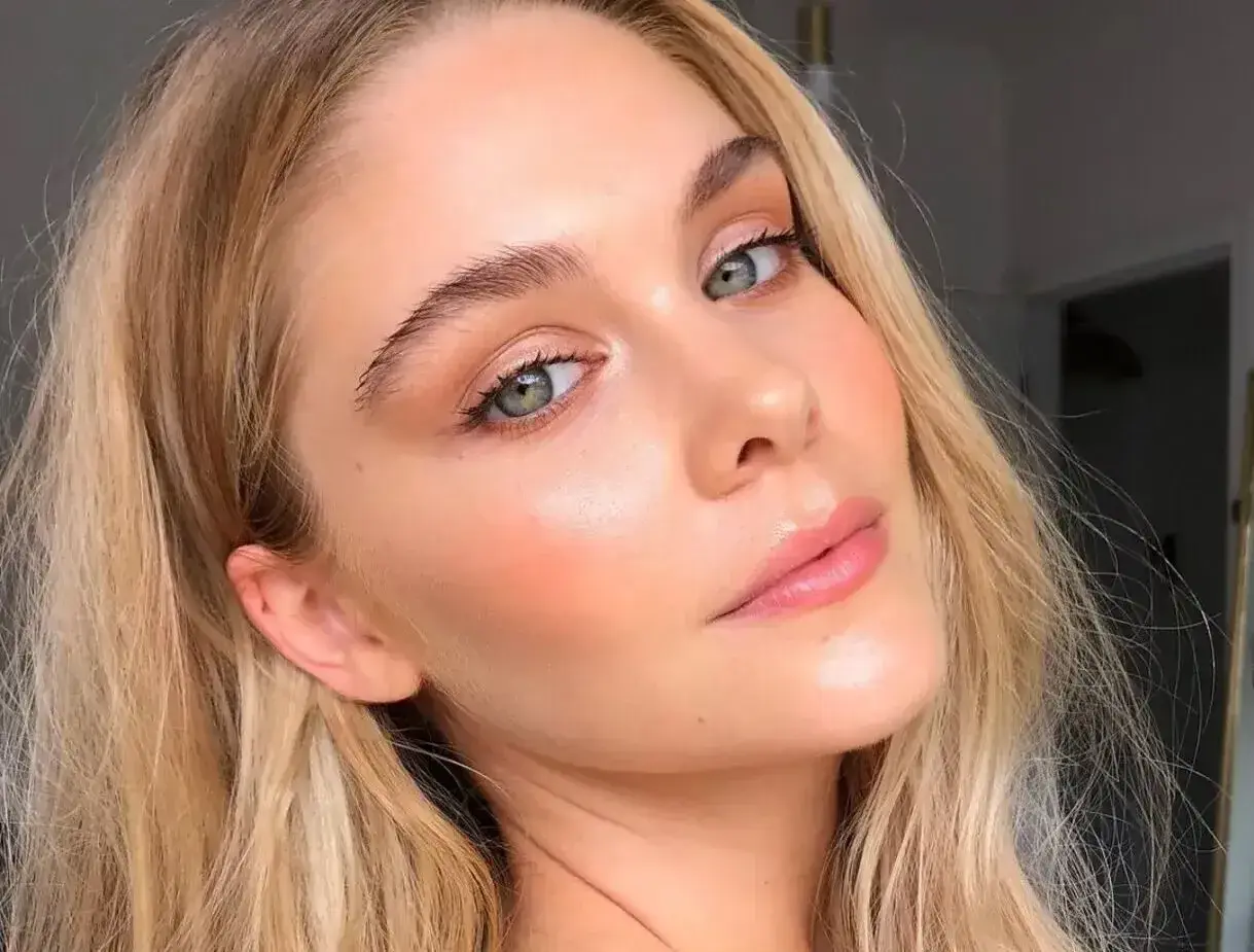 Delikatny makijaż typu "makeup no makeup" podkreśla naturalne piękno kobiety z zielonymi oczami i blond włosami.
