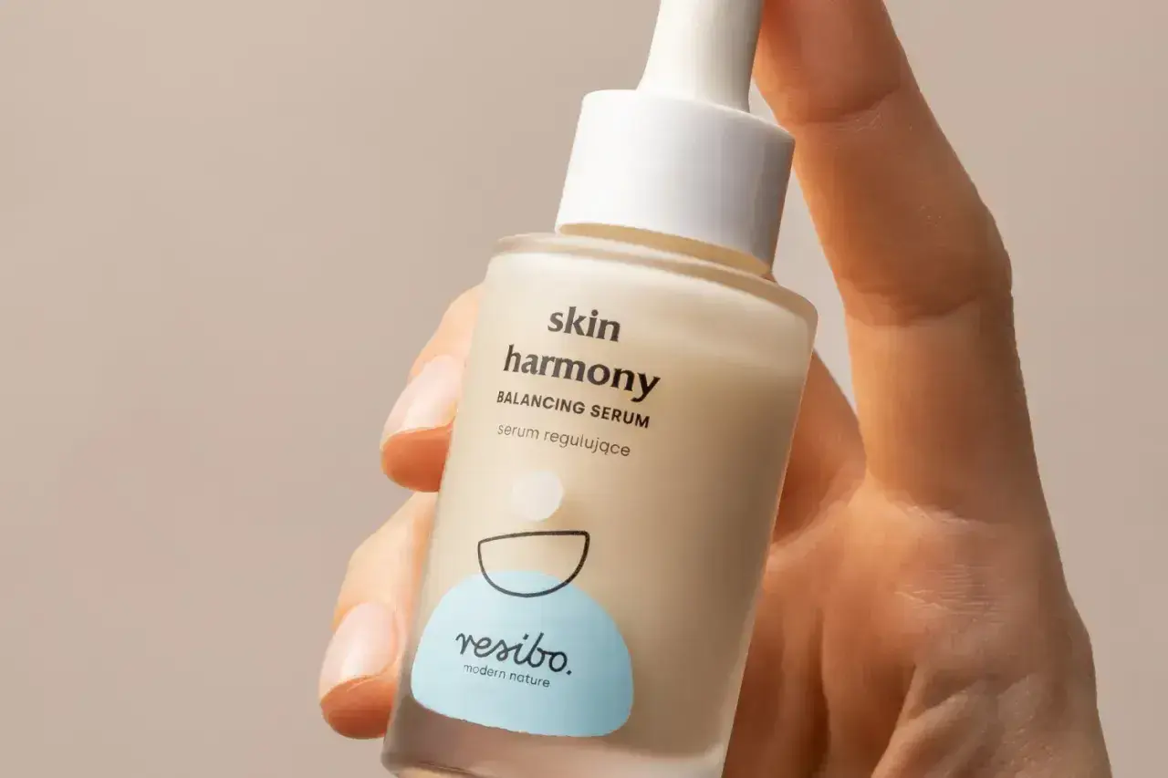 Dłoń trzyma buteleczkę serum Resibo Skin Harmony. Składnik alantoina dba o ukojenie skóry.