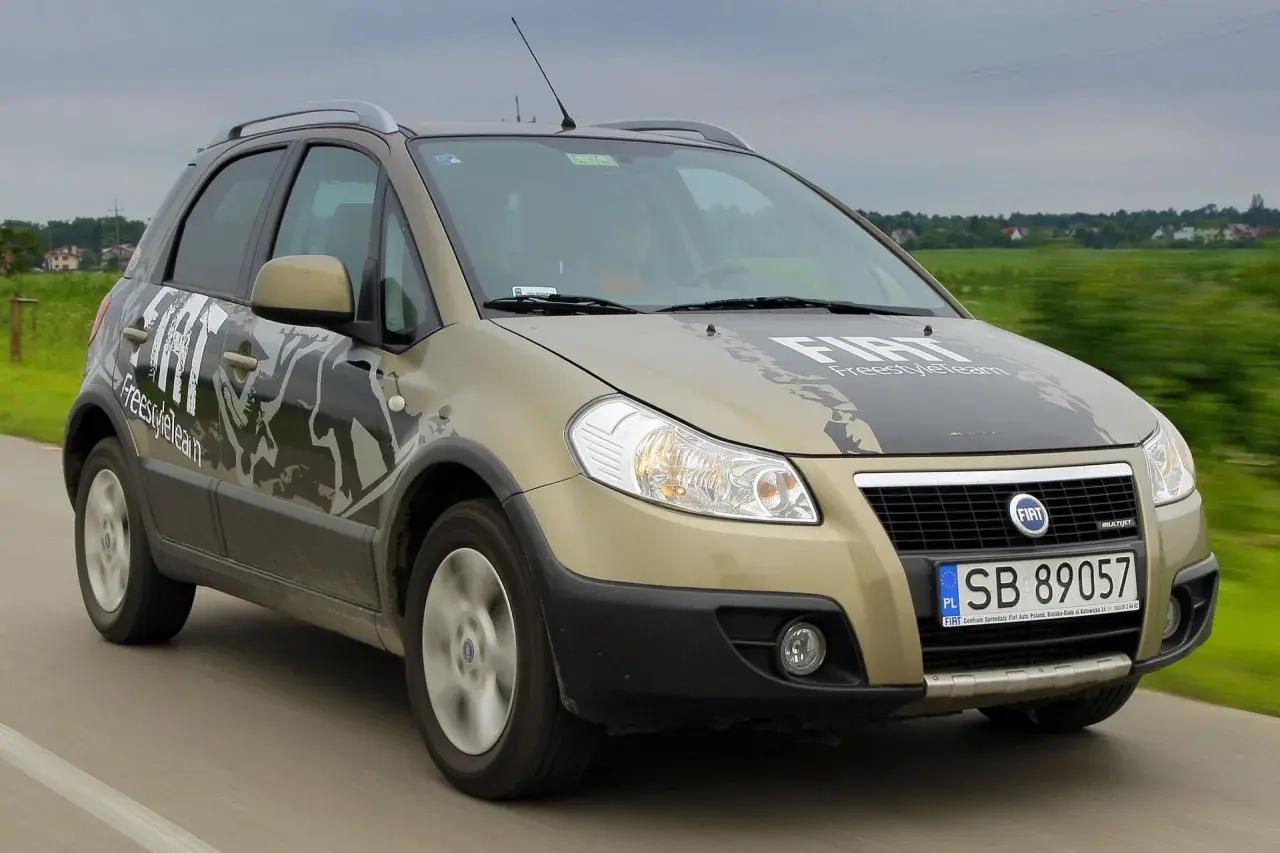 Złoty Fiat Sedici FreestyleTeam w ruchu. Wiele osób szuka opinii o tym modelu.