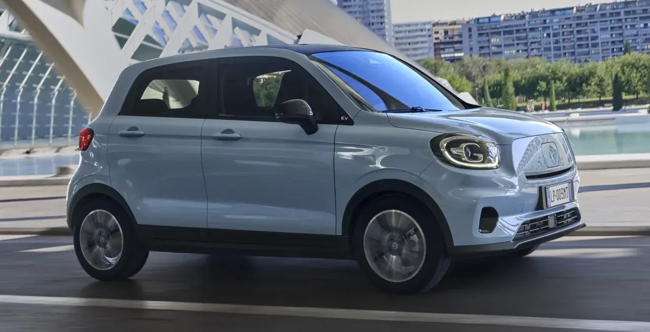Jasnoszary Leapmotor T03 na tle nowoczesnej architektury. Sprawdź, jaka jest leapmotor t03 cena i czy to auto dla Ciebie.