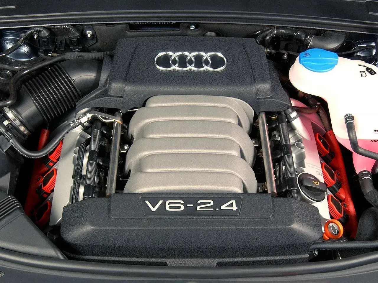 Silnik V6 2.4 benzyna z Audi A6 C6. Widoczne cewki zapłonowe i zbiornik płynu chłodniczego.