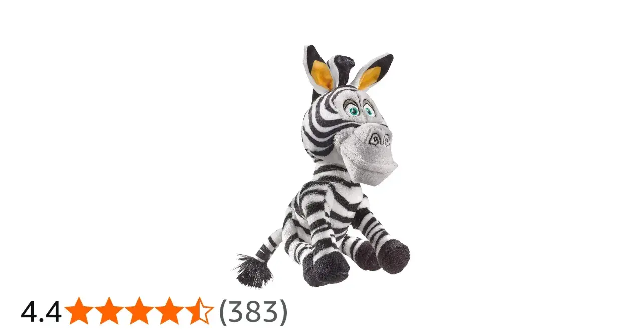 Pluszowa zebra z Madagaskaru, Marty, siedzi z szeroko otwartymi oczami i uśmiechem.