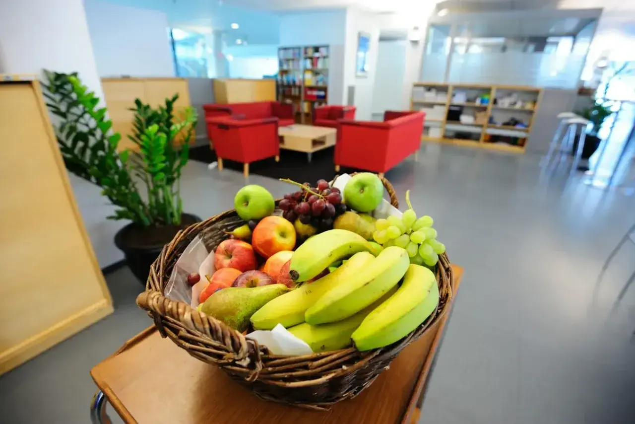 Koszyk pełen jabłek, bananów, gruszek i winogron. Idealny na owocowe czwartki w biurze.