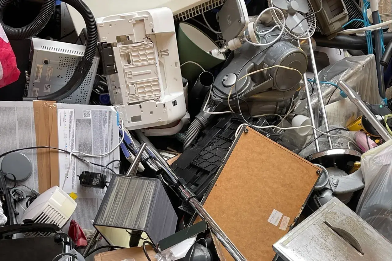 Stary sprzęt AGD, w tym odkurzacz i drukarka, tworzą stos. Zastanawiasz się, gdzie wyrzucić żelazko? To miejsce to idealny przykład elektrośmieci.