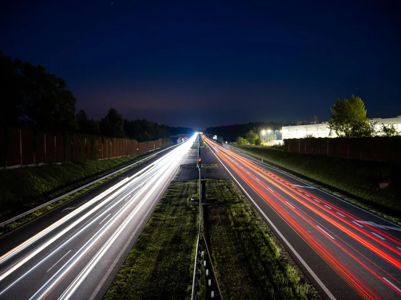 Nocne smugi świateł samochodów na autostradzie A4 między Katowicami a Krakowem. Opłaty za przejazd nie zatrzymują ruchu.