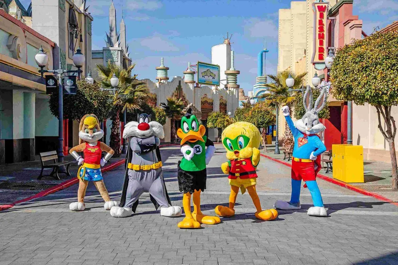 Personajes de Looney Tunes celebran la nueva atracción Warner. Bugs Bunny, Piolín, Silvestre, Lola Bunny y el Pato Lucas posan en la calle.