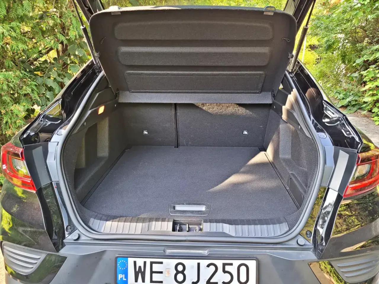 Otwarty bagażnik Renault Arkana, pokazujący jego przestronność. Wymiary bagażnika są kluczowe dla podróżujących.