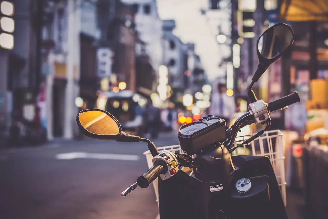 Kierownica skutera 125 z koszykiem, gotowa na miejską przygodę. Pomyśl o ubezpieczeniu motocykla 125, by podróżować bezpiecznie.
