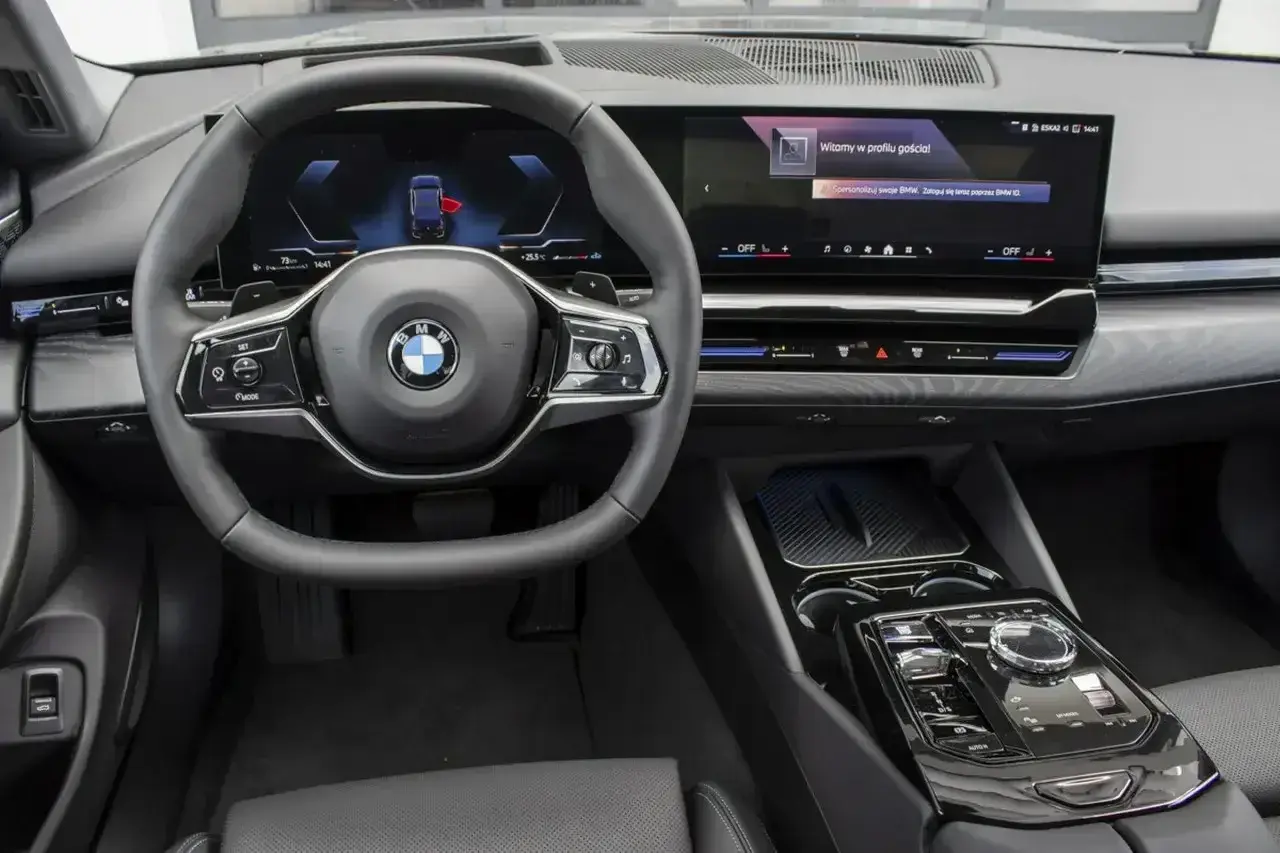 Wnętrze BMW 520d xDrive z nowoczesnym ekranem i kierownicą.
