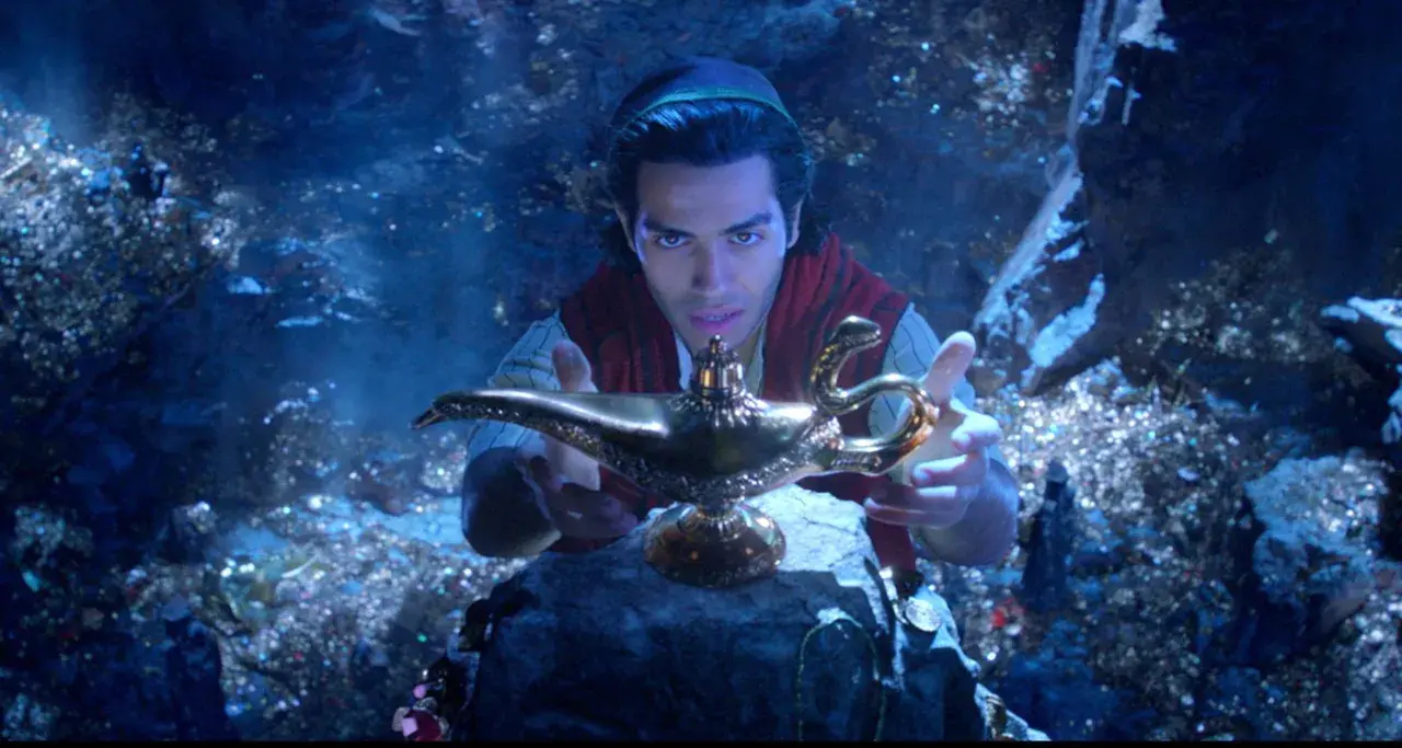 Aladyn, w mrocznej jaskini pełnej skarbów, trzymając magiczną lampę.