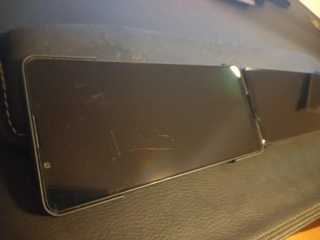 Dwa smartfony leżą obok siebie. Ekran jednego z nich, wykonany z Gorilla Glass Victus 2, nosi ślady zarysowań.