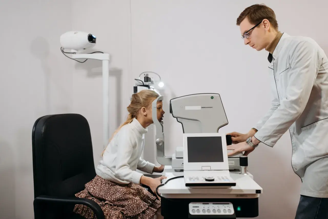 Okulista bada wzrok dziewczynki. Czy do okulisty potrzebne jest skierowanie? Zależy od placówki.
