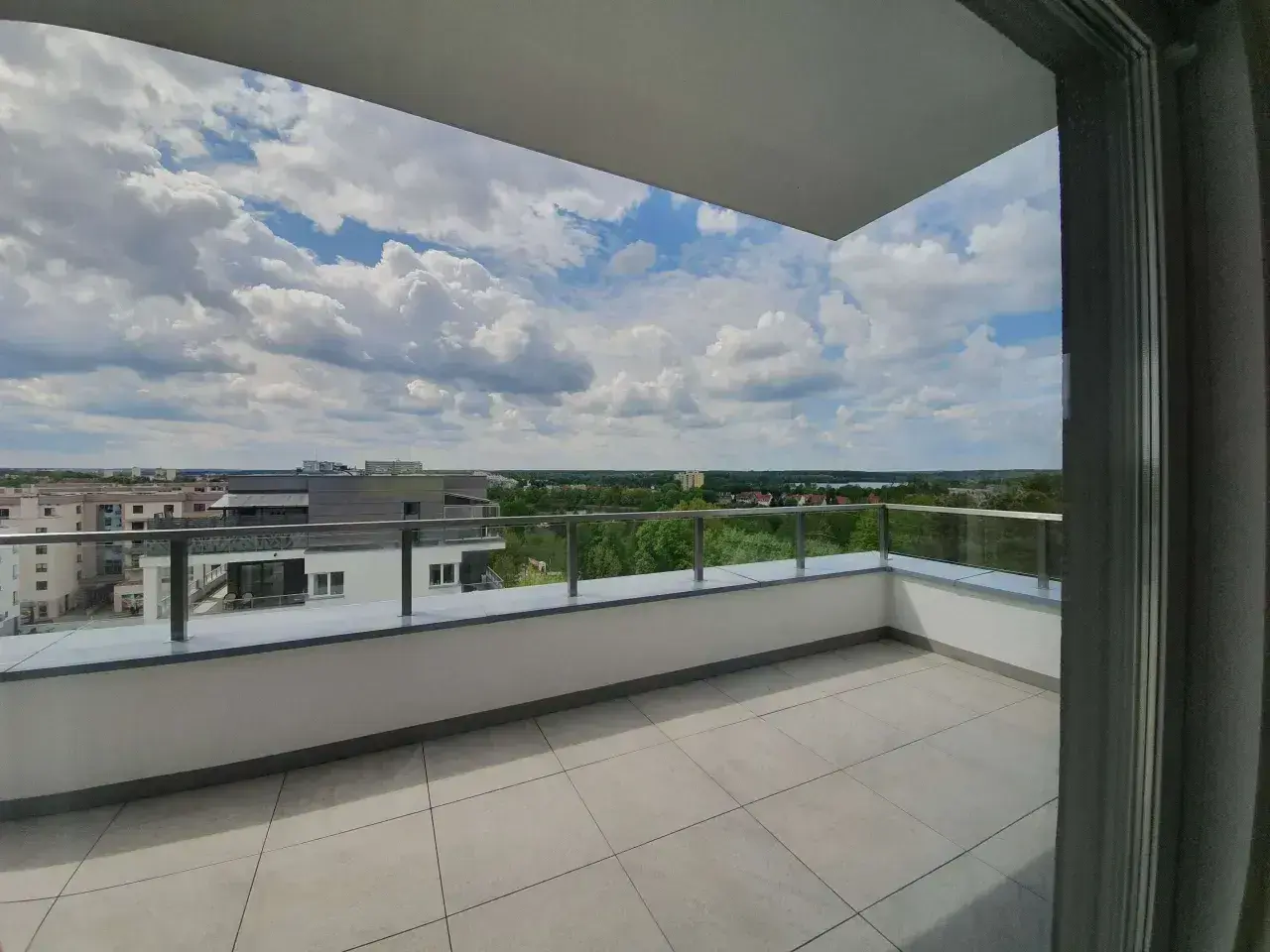 Przestronna loggia z widokiem na miasto i zieleń. Idealne miejsce na poranną kawę.