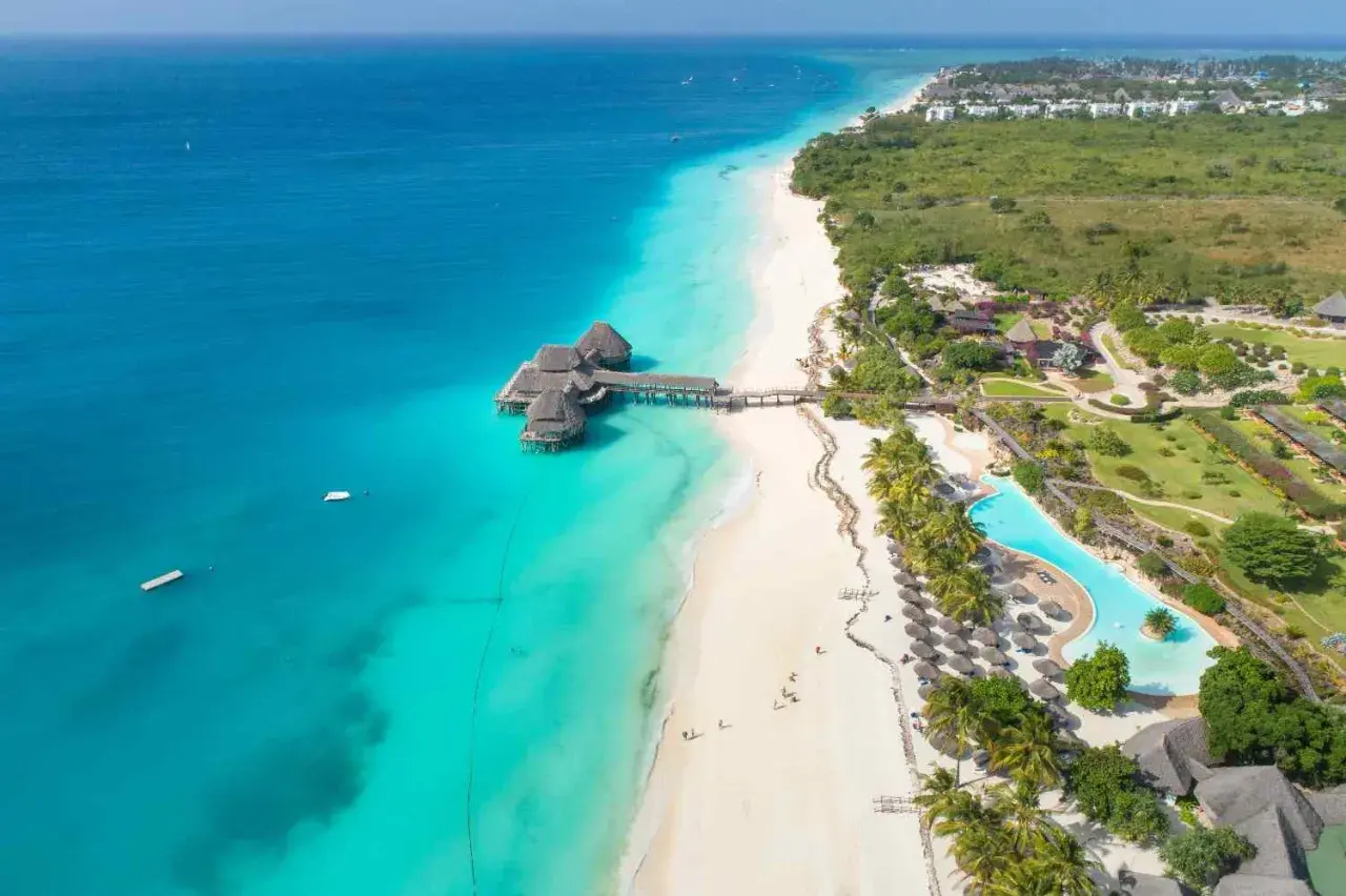 Rajskie plaże Zanzibar w lipcu: turkusowa woda, biały piasek, palmy i luksusowe bungalowy na wodzie. Idealne miejsce na wakacje.