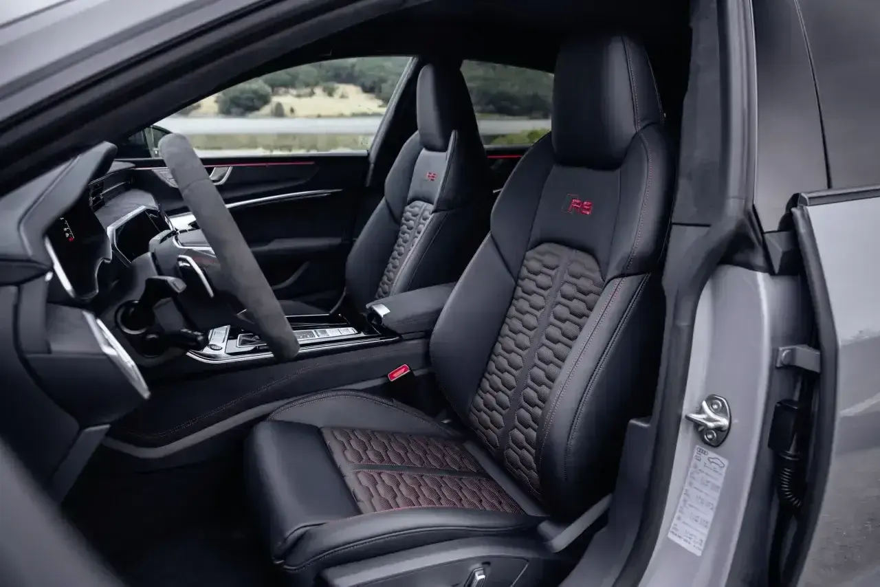 Wnętrze Audi RS7 z czerwonymi akcentami i sportowymi fotelami. Zastanawiasz się nad audi rs7 cena?