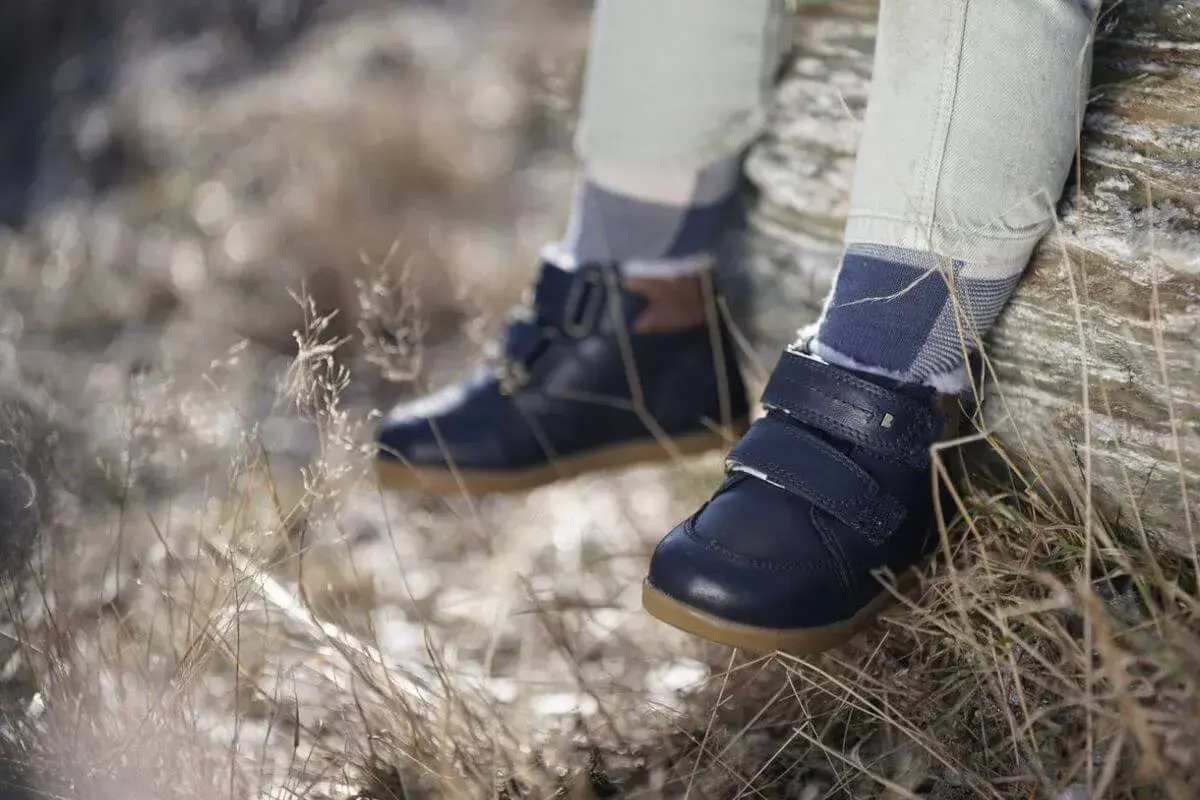 Granatowe, zimowe buty dziecięce na rzepy i sznurowadła, z futerkiem w środku. Wygodne i stylowe, idealne na jesienne i zimowe przygody. Różne marki butów oferują podobne modele.
