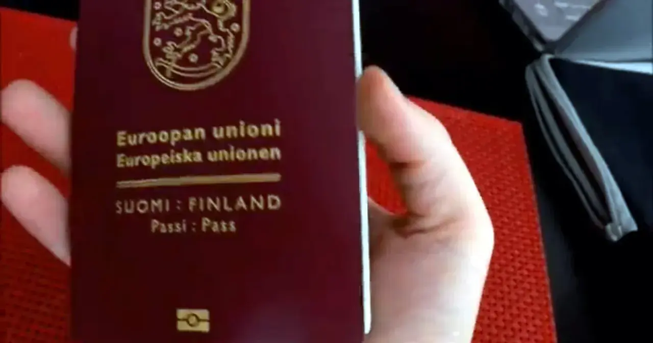 Dłoń trzyma paszport Finlandii. Czy do Finlandii trzeba mieć paszport? Tak, jeśli nie jesteś obywatelem UE/Schengen.