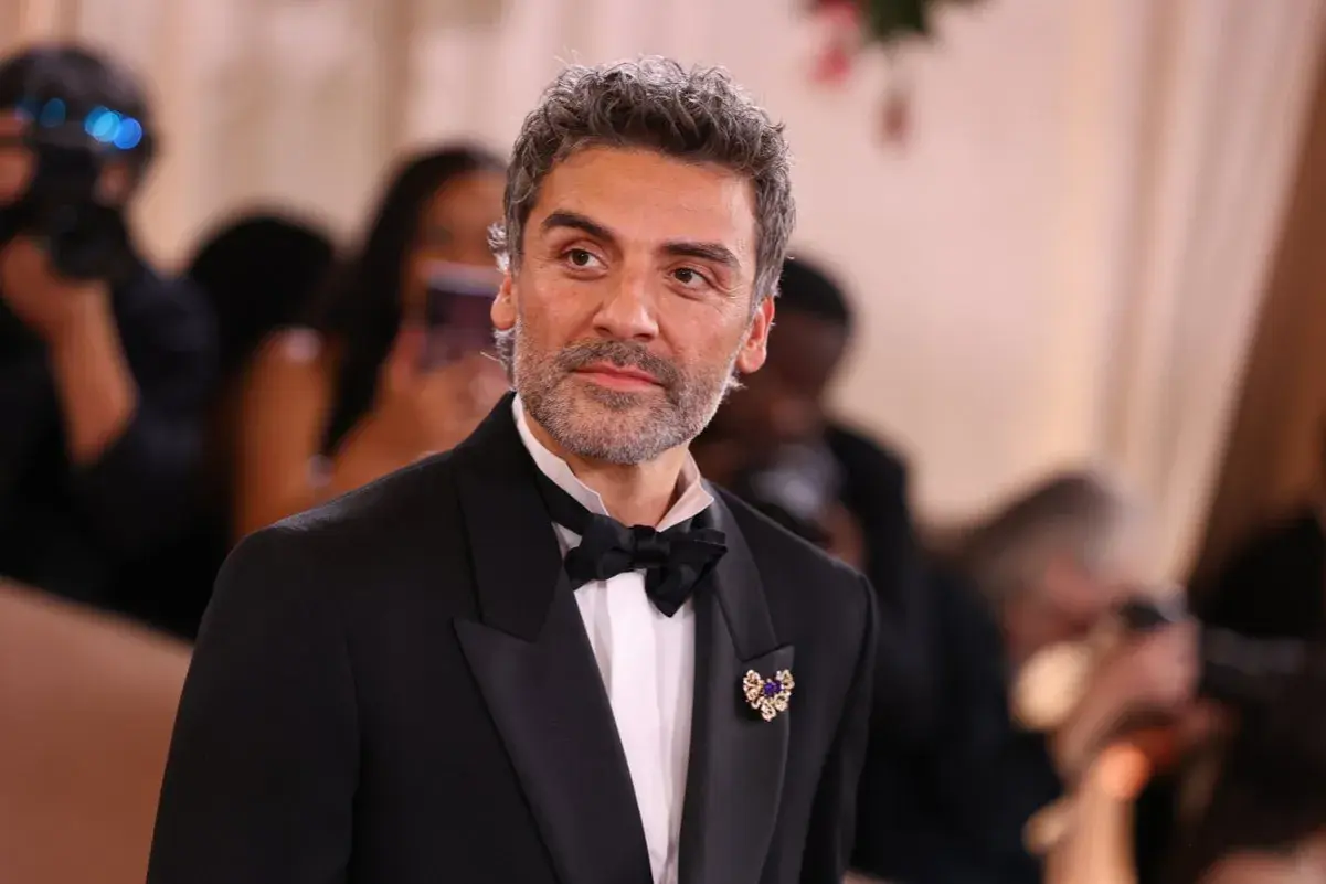 Oscar Isaac w eleganckim smokingu, gotowy na premierę swoich najnowszych filmów, seriali i programów.