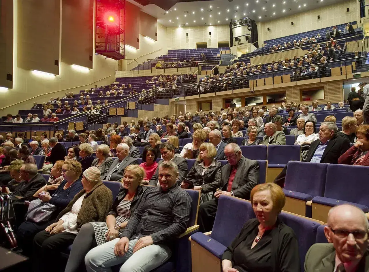 Widownia sali koncertowej, ludzie w eleganckich strojach, inspiracja: jak ubrać się na koncert muzyki filmowej.