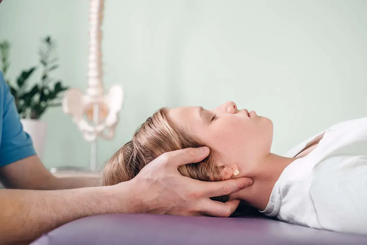 Delikatna terapia krzyżowo czaszkowa dla ulgi w napięciu. Terapeuta delikatnie uciska głowę pacjentki.