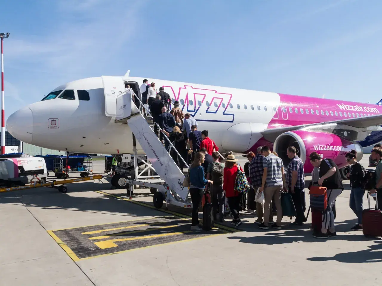 Pasażerowie Wizz Air wsiadają do samolotu. Zastanawiasz się, ile kosztuje bagaż Wizzair? Sprawdź cennik przed podróżą!