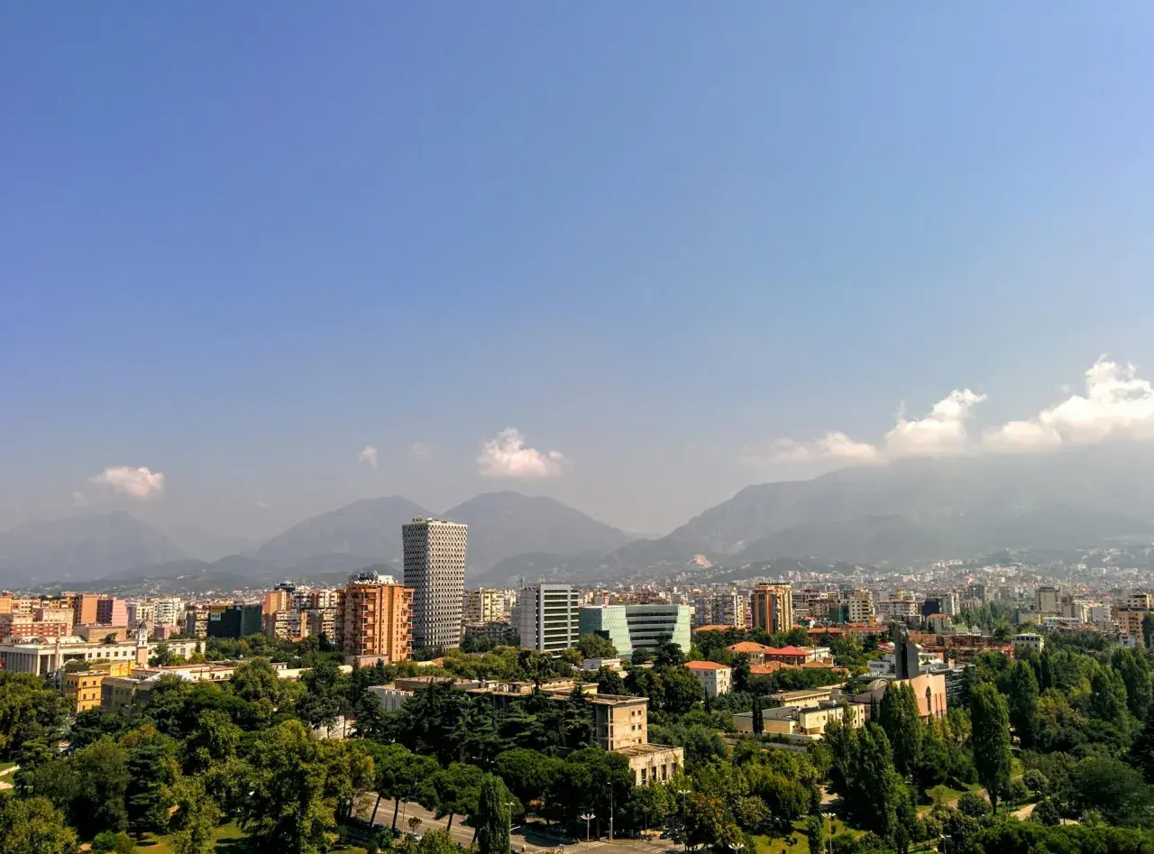 Widok na Tiranę, Albanię. Miasto z nowoczesnymi budynkami i górami w tle. Czy w Albanii jest bezpiecznie? Tak, podróżni często czują się tu bezpiecznie.